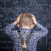 Frustrated boy next to chalk board.